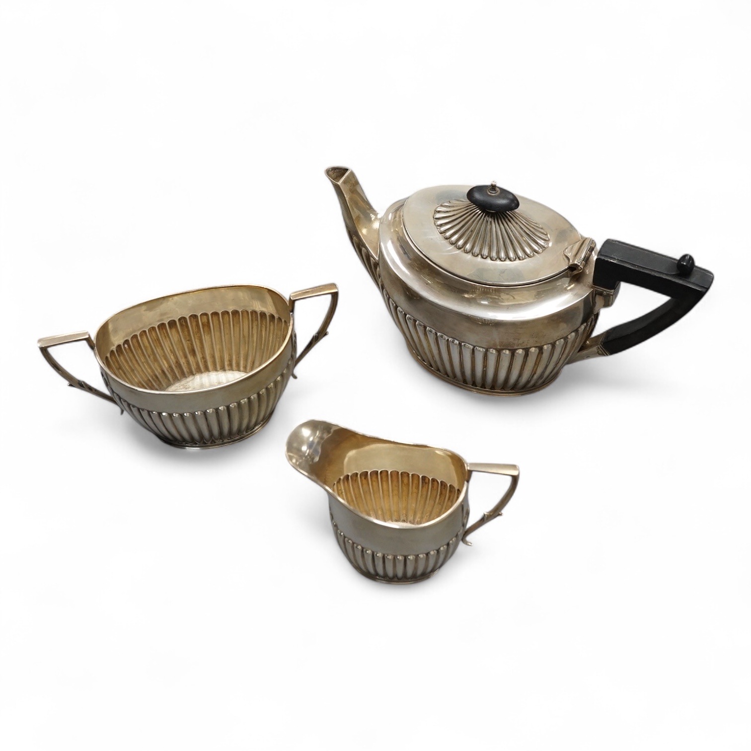 An Edwardian demi fluted silver bachelor's three piece oval tea set, by James Dixon & Sons, Sheffield, 1902, gross weight 18.8oz. Condition - fair to good